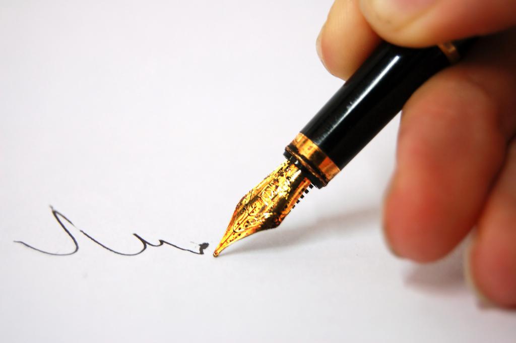 человек пишет ручкой