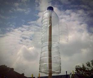 ветряк из пластиковых бутылок над клумбой