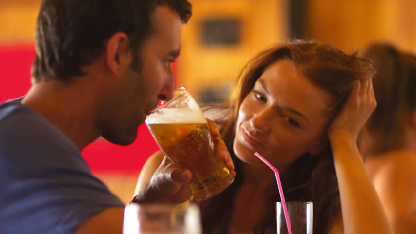 Парень пьет пиво с девушкой.
