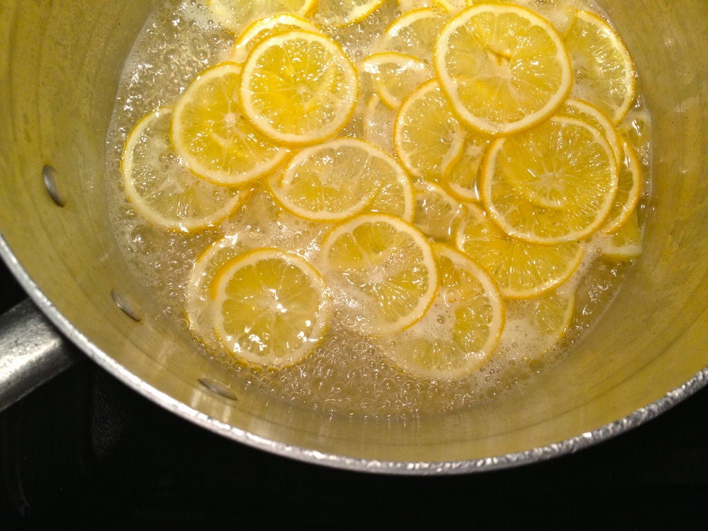 Вынимают кусочки лимонов из посудины. 